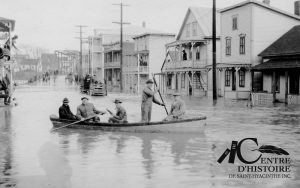 L'inondation de 1927 sur la rue Cascades. On aperçoit le pont de la Société (à l'emplacement de l'actuel pont Bouchard) en arrière-plan. Centre d'histoire de Saint-Hyacinthe, CH478 Collection de la Société d'histoire régionale de Saint-Hyacinthe.