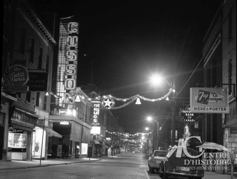 La rue des Cascades illuminée.1961. - Fonds Raymond Bélanger, CH548.Voici une belle photo de la rue des Cascades au mois de décembre 1961. La rue est paisible et illuminée. Vraisemblablement, elle sera plus animée lorsque les magasins seront ouverts jusqu'à 22 heures.