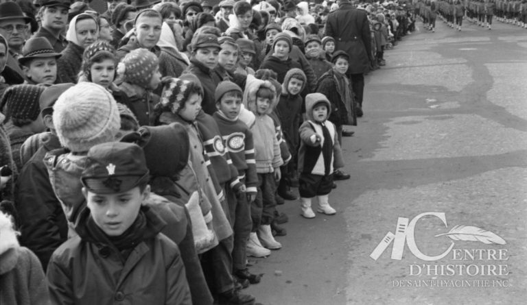 « Y arrives-tu? »1962. - Fonds Raymond Bélanger, CH548.Il y a toujours beaucoup de monde lors des défilés du Père Noël. Cette scène captée par Raymond Bélanger, en 1962, témoigne de la popularité du Père Noël.
