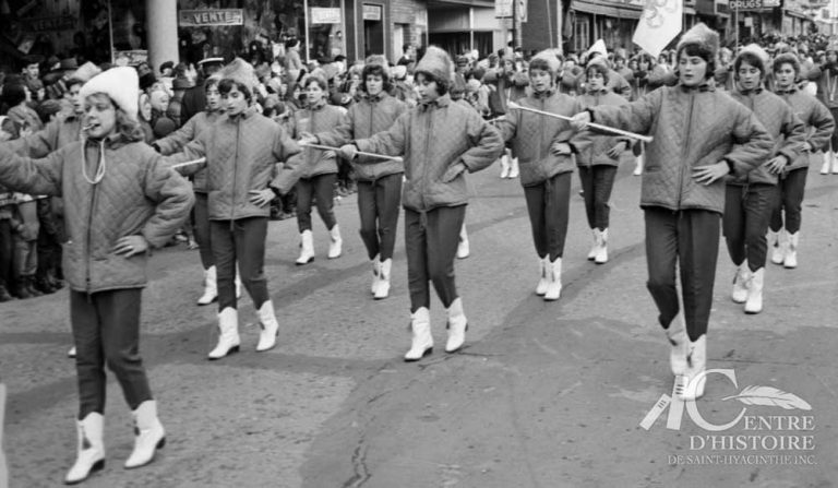 Les majorettes.1962. - Fonds Raymond Bélanger, CH548.En 1962, une dizaine de fanfares, corps de clairons et de majorettes défilent lors de la parade du Père Noël. Sur la photo, nous voyons quelques membres des Cocardières de Sherbrooke, une troupe dès plus appréciée par les 25 000 spectateurs.