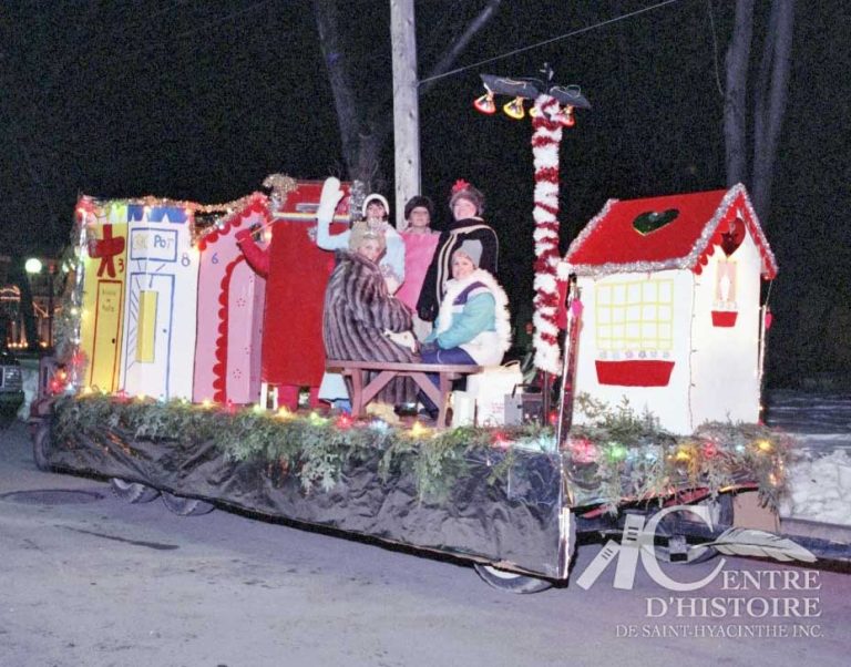 En soirée!1987. - Fonds Brodeur & Poitras, photographes, CH214.Depuis le premier défilé du Père Noël, en 1955, l'événement qui regroupe la communauté d'affaires du centre-ville se déroule parfois en soirée comme témoigne ce cliché réalisé en 1987.